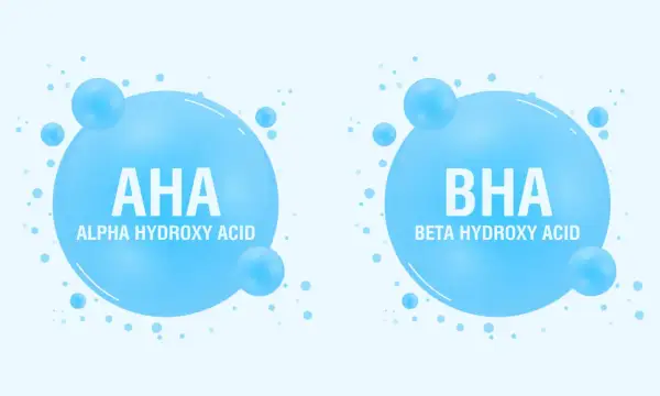 Dwa bąbelki z napisem AHA (Alpha Hydroxy Acid) i BHA (Beta Hydroxy Acid), symbolizujące składniki kosmetyków.